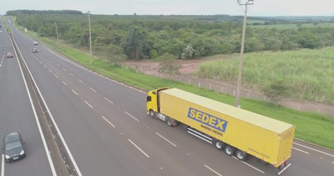 Ribeirao Preto, Sao Paulo / Brazil - Circa January 2019: Aerial image of a yellow Brazilian postal truck traveling on the highway. Delivery of postage by country. 4K.