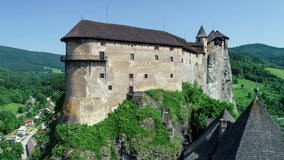 Orava castle - Oravsky Hrad in Oravsky Podzamok village in Slovakia. Medieval stronghold on extremely high and steep cliff by the Orava River. Aerial 4K revealing video in summer
