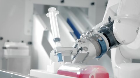 A robotic arm makes an injection with chemotherapy medicine. Two manipulators fills the drug into a syringe. New technologies in medicine, innovations. Remote treatment of cancer patients and infected