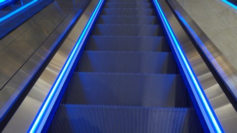 Empty staircase of a moving escalator with backlight in 4K.
