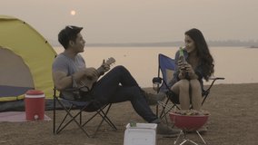 young couple camping in the riverside there is a barbecue and drink with singing joyfully footage 4k video 