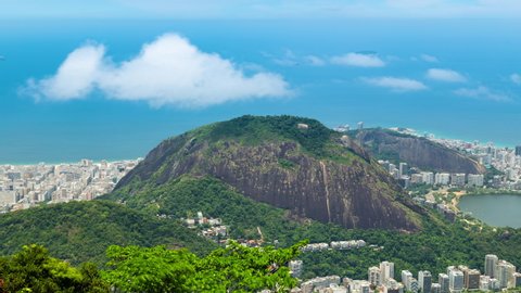 Aerial timelapse of the Copacabana and Ipanema in Rio de Janeiro, Brazil. View of the city and Morro hill with cloud passing over. Ocean and beach in the background.