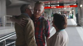 Happy senior couple standing in airport terminal and greeting their young son. Parents happy to see their child after long travel. Aged mother and father meeting son at railway station - Powered by Shutterstock - Get 15% off with code: PIKWIZARD15