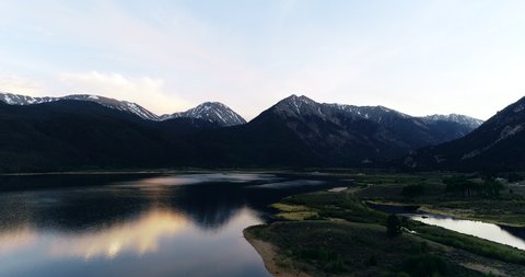 Drone aerial of high alpine mountain lake at sunset