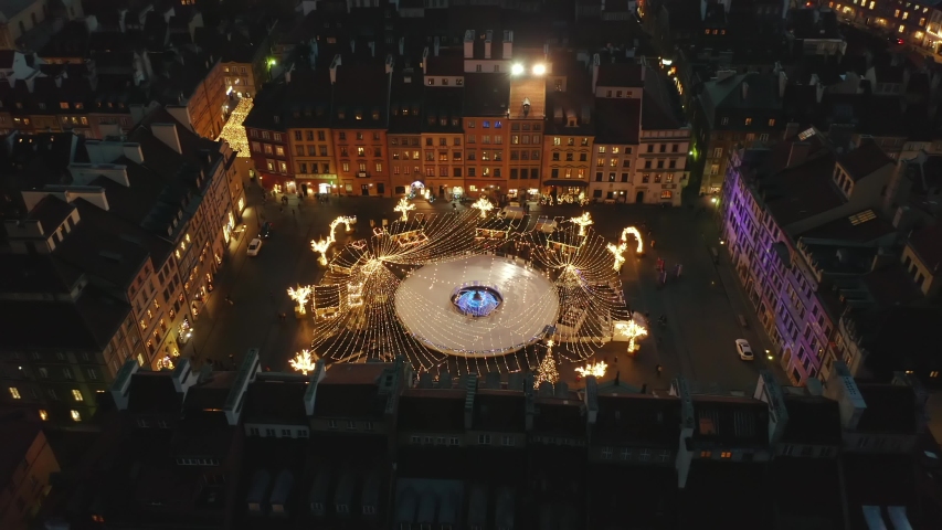 Aerial view of an ice skating in the historic center of Warsaw. The skating rink is decorated with bright New Year