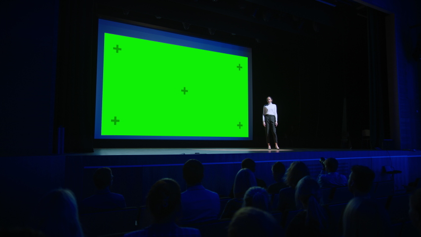 Keynote Speaker Announces New Product to the Applauding Audience, Behind Her Movie Theater with Green Screen, Mock-up, Chroma Key. Female CEO Shows Leadership on Business Live Event or Device Reveal