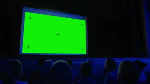 In the Movie Theater Captivated Audience Watching New Blockbuster Film on Mock-up Green Screen. People Watching Video Game Tournament Streaming, Live Concert Video, New Product Release Trailer