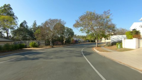 Rear facing driving point of view POV of quiet Australian suburban city street - ideal for interior car scene green screen replacement