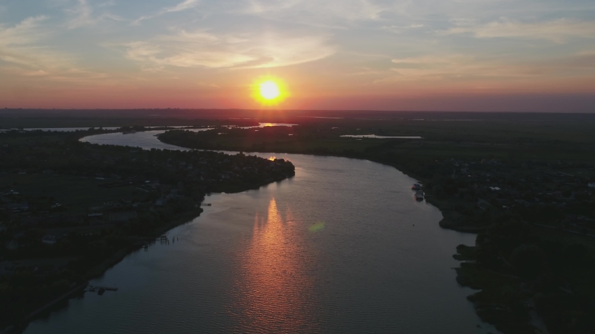 Village on the river bank in Russia, video from a drone at sunset
