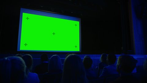 In the Movie Theater Captivated Audience Applauds after Watching New Blockbuster Film on Mock-up Green Screen. People Watching Video Game Tournament Streaming, Live Concert Video, New Product Release