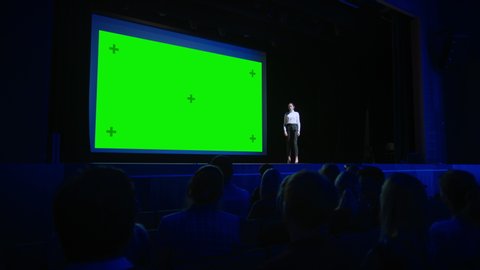 On Stage: Visionary Speaker Does Presentation of the New Product, Behind Her Movie Theater with Green Screen, Mock-up, Chroma Key. Female CEO Shows Leadership on Business Live Event or Device Reveal