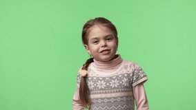 Little girl in pink dress enjoys dancing, playing, jumping game. Object over green background for keying and combine these footage with other elements. Studio shot people emotions. 4K video