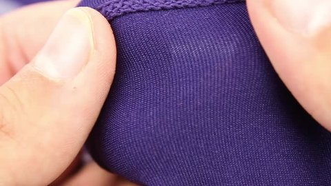 human hand testing purple synthetic thermal underwear, closeup(macro), outer side and wrong side