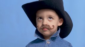 cowboy child with a brown mustache and a hat stands on a blue background - Powered by Shutterstock - Get 15% off with code: PIKWIZARD15