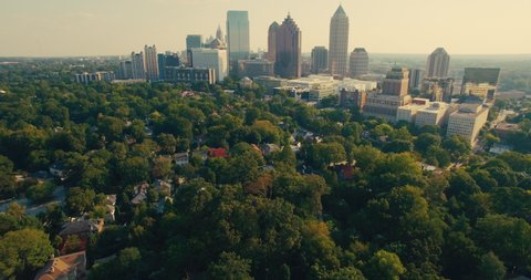 Aerial view of downtown Atlanta, Georgia and suburban neighborhoods in the state capital. Dron shot in a summer sunset featuring a beautiful skyline of Atlanta, Georgia USA.