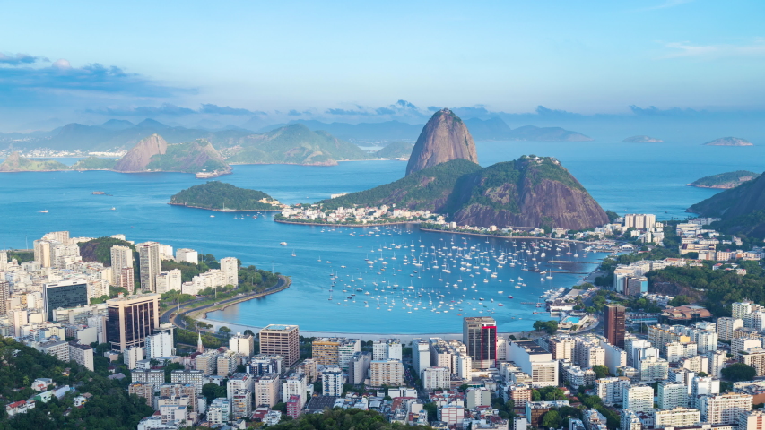 Day to night sunset timelapse of the Sugarloaf mountain in Rio de Janeiro, Brazil. View of Botafogo city buildings. Guanabara bay full of Boats and ships. Peak, rocky hills and mountain in background. Royalty-Free Stock Footage #1045137124