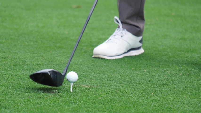 Professional golfer started a game golf. Golfer taking shot on the golf course.
