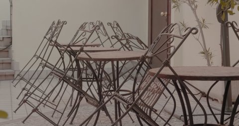 Panning Reveal of Restaurant Empty Patio with Rustic Metal Chairs Leaning on Tables
 에디토리얼 스톡 비디오