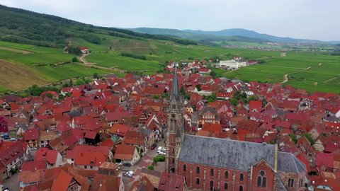 A beautiful top view, shoted from a drone, to the small Alsatian village Dambach-la-Ville. Stunning cathedral and beautiful green hills with vineyards around.
