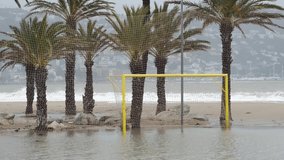 Football goal in the water on palm trees and a storm background. The consequences of Hurricane Gloria.Storm Gloria raging in Spain, Europe. Big waves on Mediterranean Sea in Catalonia, Roses city. 
