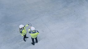 Industry 4.0 Modern Factory: Two Engineers Use Digital Tablet Computer with Augmented Reality Software Visualizing of Manufacturing Plant Room Mapping. Doing 3D Factory Floor Layout. High Angle Shot - Powered by Shutterstock - Get 15% off with code: PIKWIZARD15
