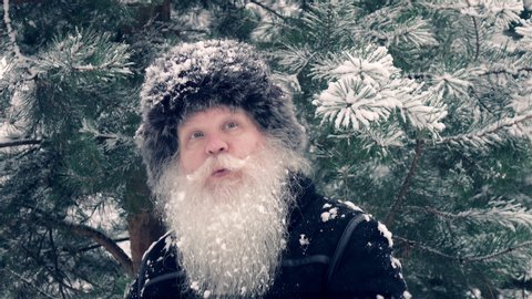 Funny middle aged man dancing and whistling a song at winter forest in high speed recording. Closeup outdoors winter portrait in 4K. Healthy cheerful retired person. Smiling senior grey-haired male.