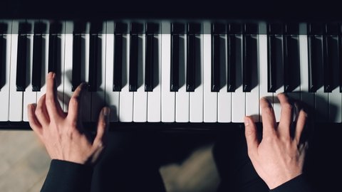 Close-up of pianist's hands professionally play the piano