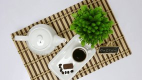 Hot black coffee on the table, coffeepot, glasses, a dish on a white background, various sweets, baked, chocolate, natural flowers, white English services. Rotating, 1920x1080. FHD.