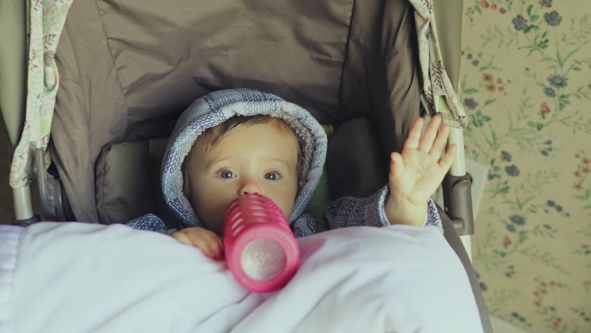 Baby girl drinking milk with a bottle 