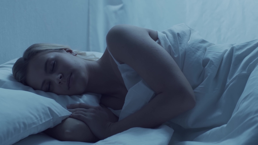Young woman lying in the bed. Beautiful blond sleeping girl. Morning in the bedroom. Health and rest concept. | Shutterstock HD Video #1045191619