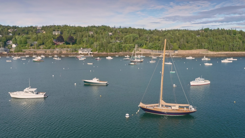 Aerial: Flying over boats moored in the harbor and small island. Seal Harbor, Mt Desert Island, Maine, USA 