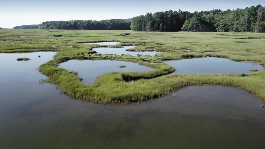 Aerial: tidal flats, marsh land, estuary, islands & forest, Maine, USA