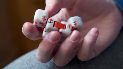 Colorful fingers antistress fidget cube toy in hand of little boy. development of fine motor skills of fingers of children