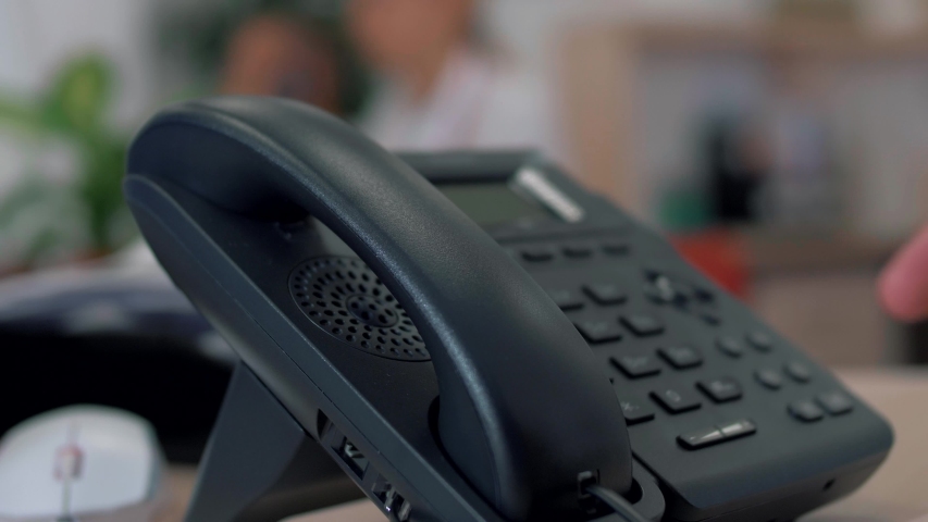 Office worker uses a landline phone to answer incoming calls. Close-up Royalty-Free Stock Footage #1045213606