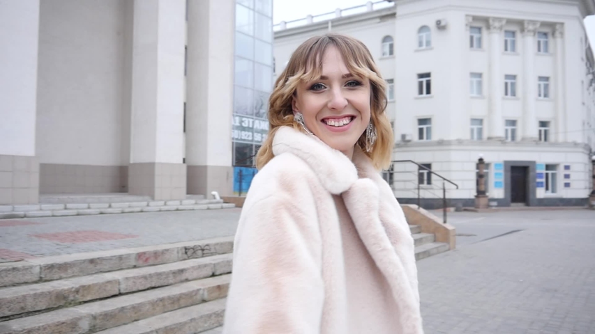 Elegant Woman wear Fur Coat posing on a Street - cold Autumn Day