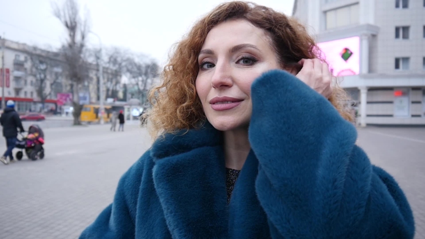 Elegant Woman wear Fur Coat posing on a Street - cold Autumn Day