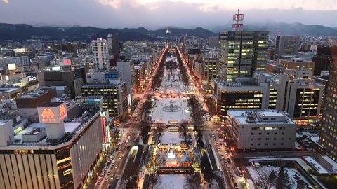Sapporo, Japan - December 20, 2019 : Day to night time lapse of Odori park from Sapporo TV Tower