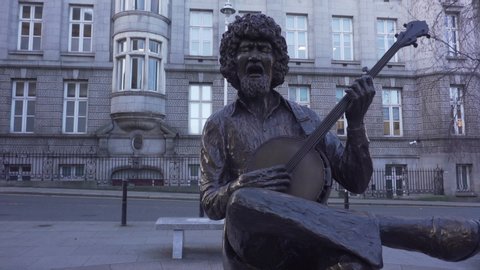 Dublin, Ireland - January 17, 2020: life-sized seated bronze statue of Irish folk musician Luke Kelly on South King Street.
