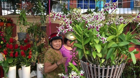 VUNG TAU, VIETNAM - JANUARY 2020: Unidentified Vietnamese women choose flowers on Tet Eve (Vietnamese New Year) at a street marketplace.