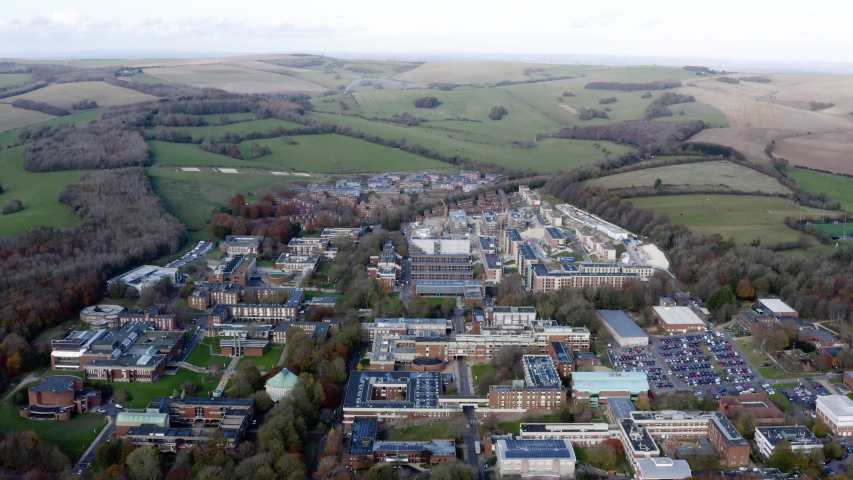 The University of Sussex aerial view in Brighton. Flying above the campus surrounded by a National Park, with open spaces and buildings of architectural merit in Falmer, Sussex, England UK Royalty-Free Stock Footage #1045227274