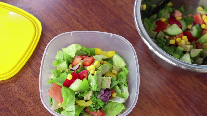 put fresh salad with  cucumber  tomaotes avocado corn  parsley in to plastic food container