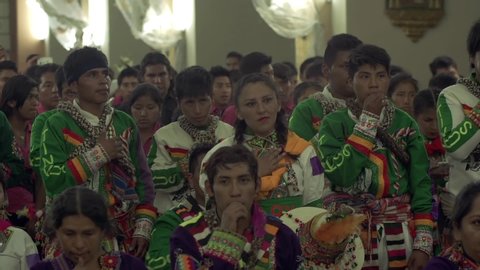 COCHABAMBA / BOLIVIA - August 2019: Bolivian Dancers wearing Carnival Uniform and Praying in the Church, during the Urkupiña Festival, in Bolivia.