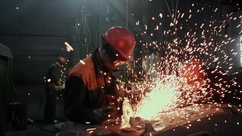 Manufacture of Railcar or Carriage, Train Wagon Production, Factory Workers are Welding in Protective Helmets and Glasses, Beautiful Epic Shot, Dolly Out, Slow Motion