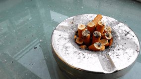 burned cigarette in ashtray on the table.