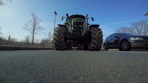 FUERTH/NUREMBERG, BAVARIA, GERMANY - 17. JANUARY 2020: Massive farm tractor goes over the camera. Unique angle from convoy of protesting farmers in Fürth/Nürnberg