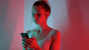 close up portrait of the stylish blonde young girl use smartphone among neon lights music 5g. Woman use technology social shopping - Powered by Shutterstock - Get 15% off with code: PIKWIZARD15