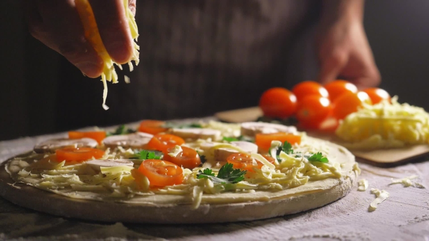 Close up view of a man chef cooking italian pizza. The process of making pizza at table . Fresh dough on kitchen table. Cooking at home during isolation period, pandemic 2020. Stay home concept | Shutterstock HD Video #1045260718