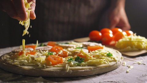 Close up view of a man chef cooking italian pizza. The process of making pizza at table . Fresh dough on kitchen table. Cooking at home during isolation period, pandemic 2020. Stay home concept Video stock