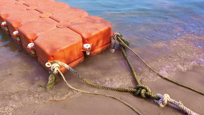 Rest and travel to sea with orange buoy foam bridge floating on beach in summer sea and movement with waves.