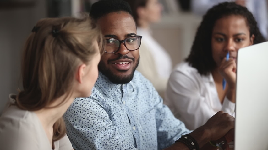 Confident smart african american manager in eyeglasses explaining corporate software details to motivated mixed race female colleagues. Smiling multiracial employees listening to leader instructions. Royalty-Free Stock Footage #1045279321